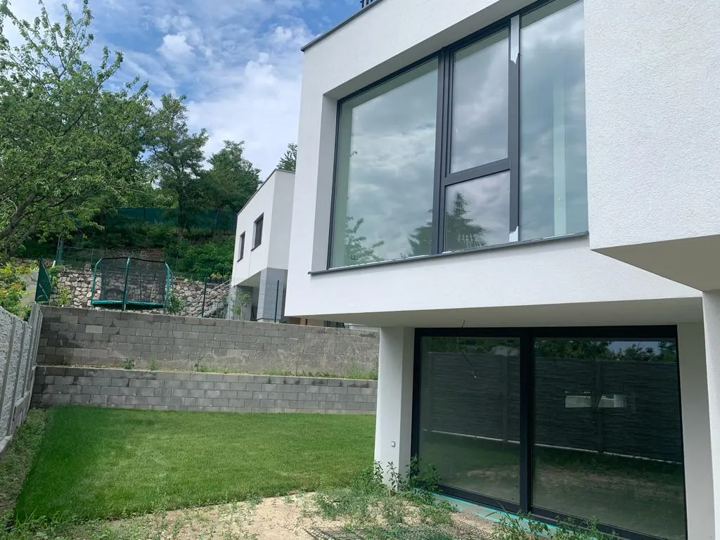 Moderný rodinný dom s veľkými oknami a záhradou