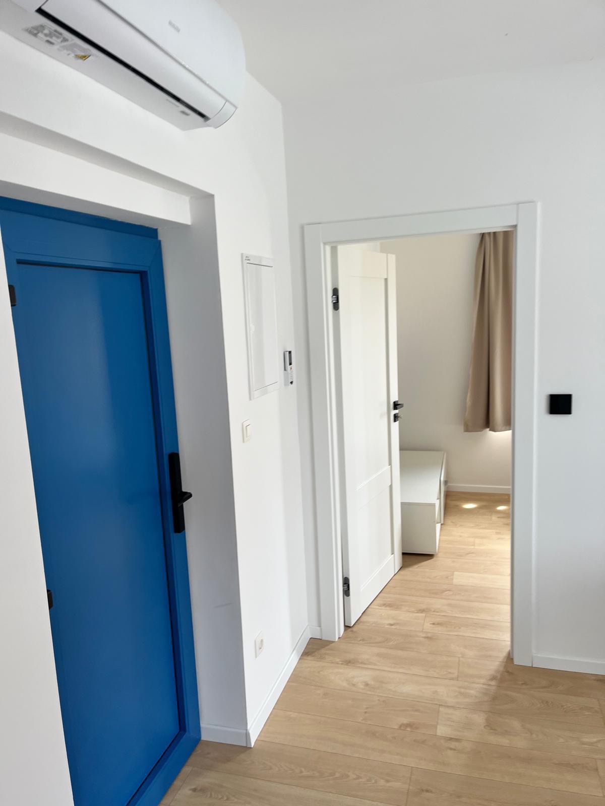 Chodba apartmánu po rekonštrukcii s novými dverami a klimatizáciou