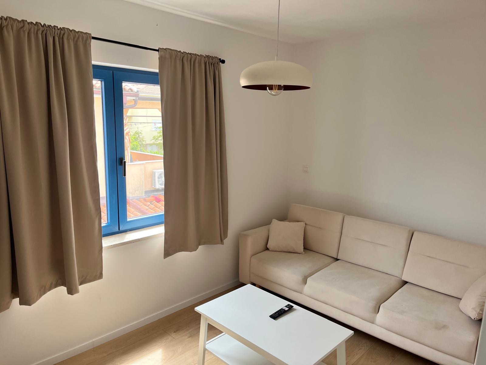 Obývačka zrekonštruovaného apartmánu s rozkladacím gaučom a novými oknami