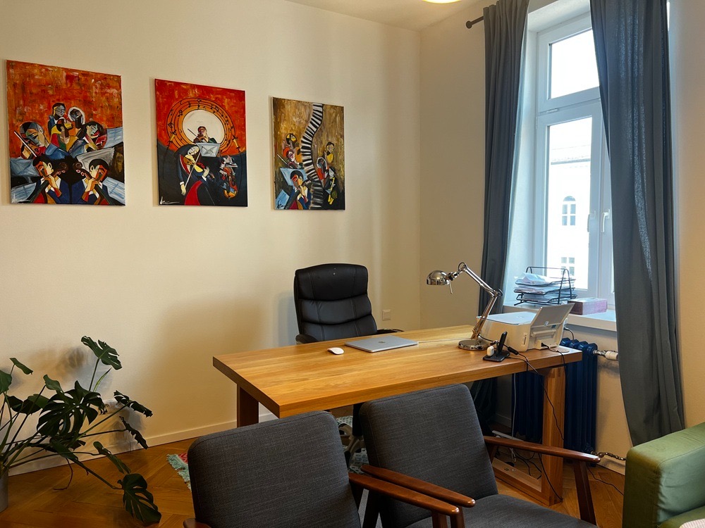 Pracovný stôl s lampou a obrazmi na stene v pracovni v Dolnom Kubíne