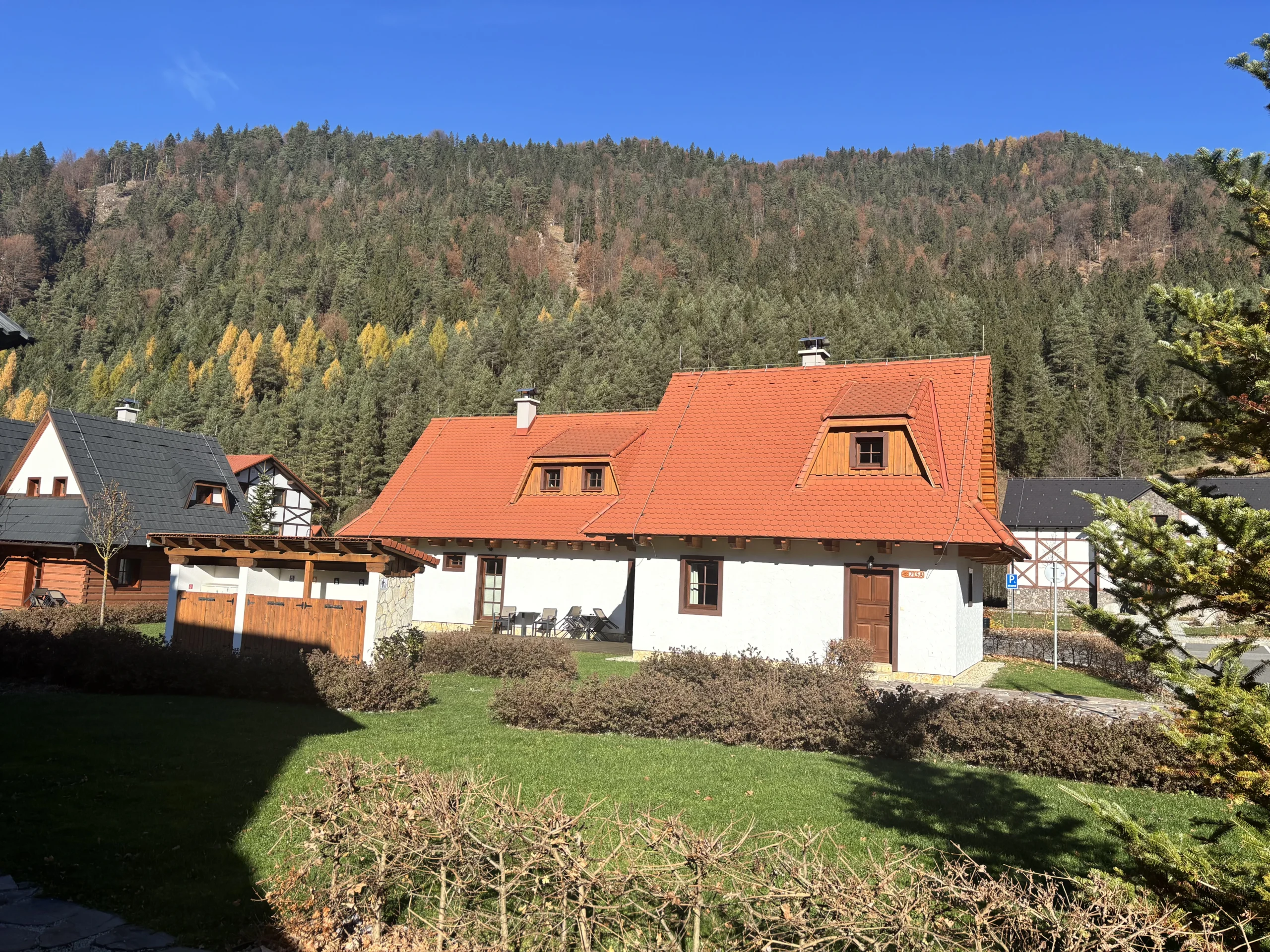 Apartmánový dom s oranžovou strechou a vikiermi na Liptove